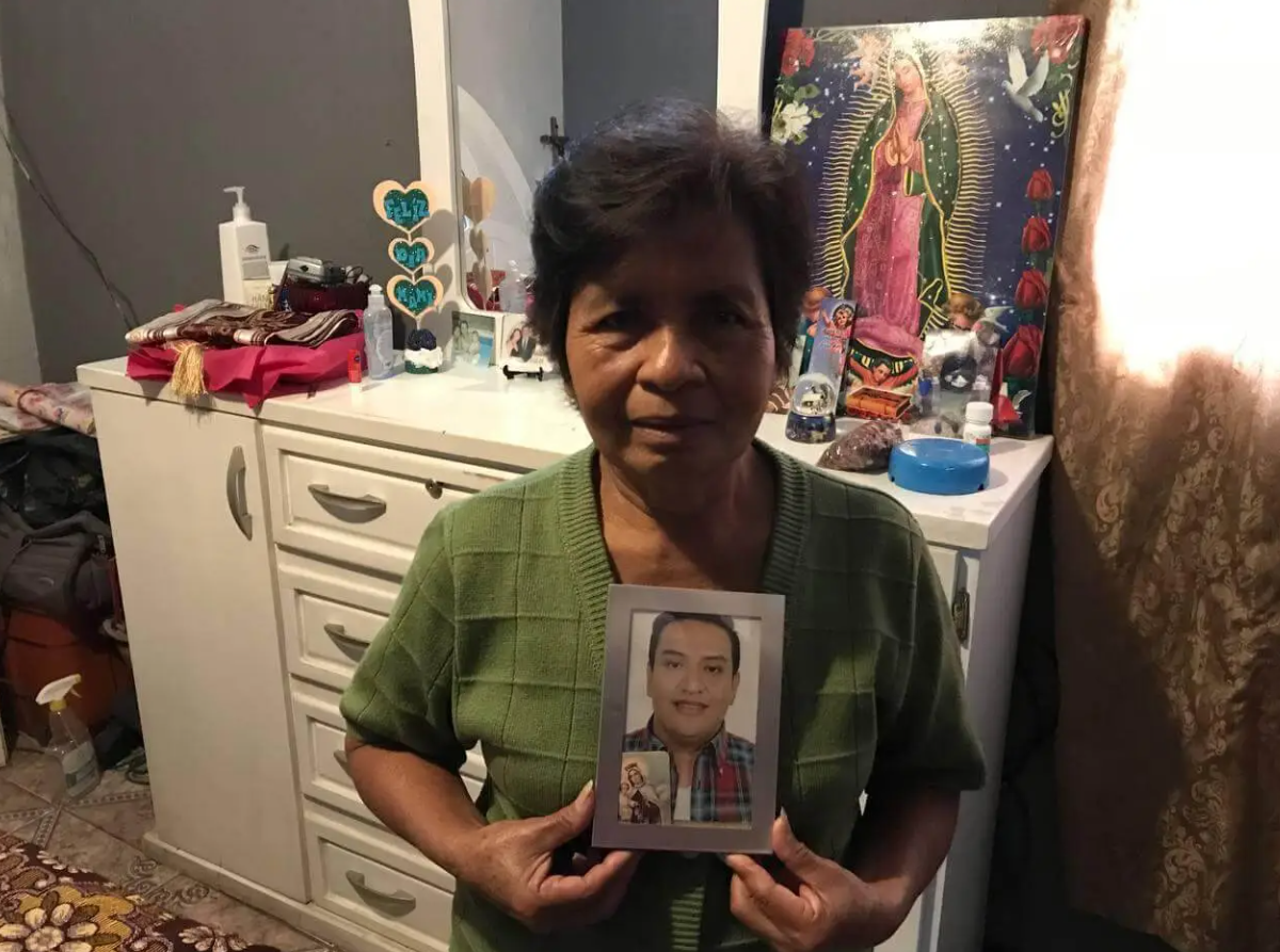  María sostiene el retrado de Mario López, su último empleador, fallecido por Covid-19. Foto: Paolina Albani. 